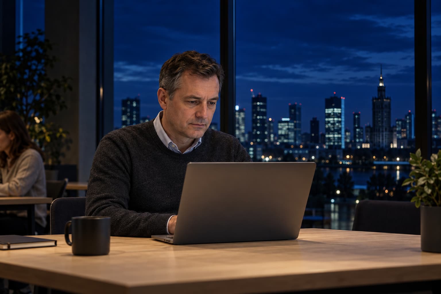 Adult learning on a laptop in a training room at dusk